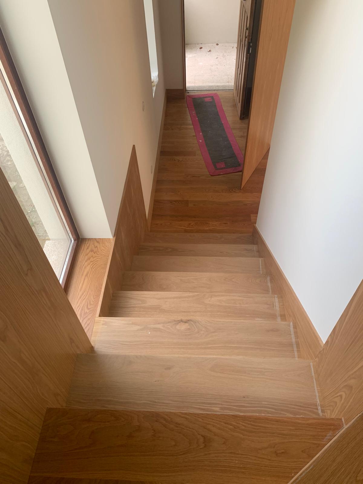 Oak winder staircase descending to an entrance hall with oak flooring
